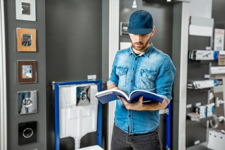 plombier consultant un manuel technique dans une salle de plomberie